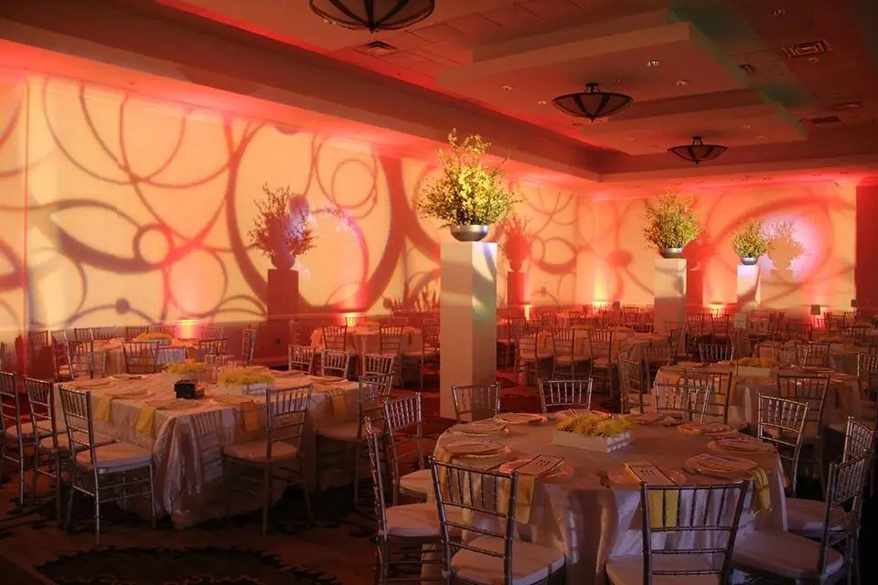 Coral and amber uplighting with a pattern wash across a banquet room