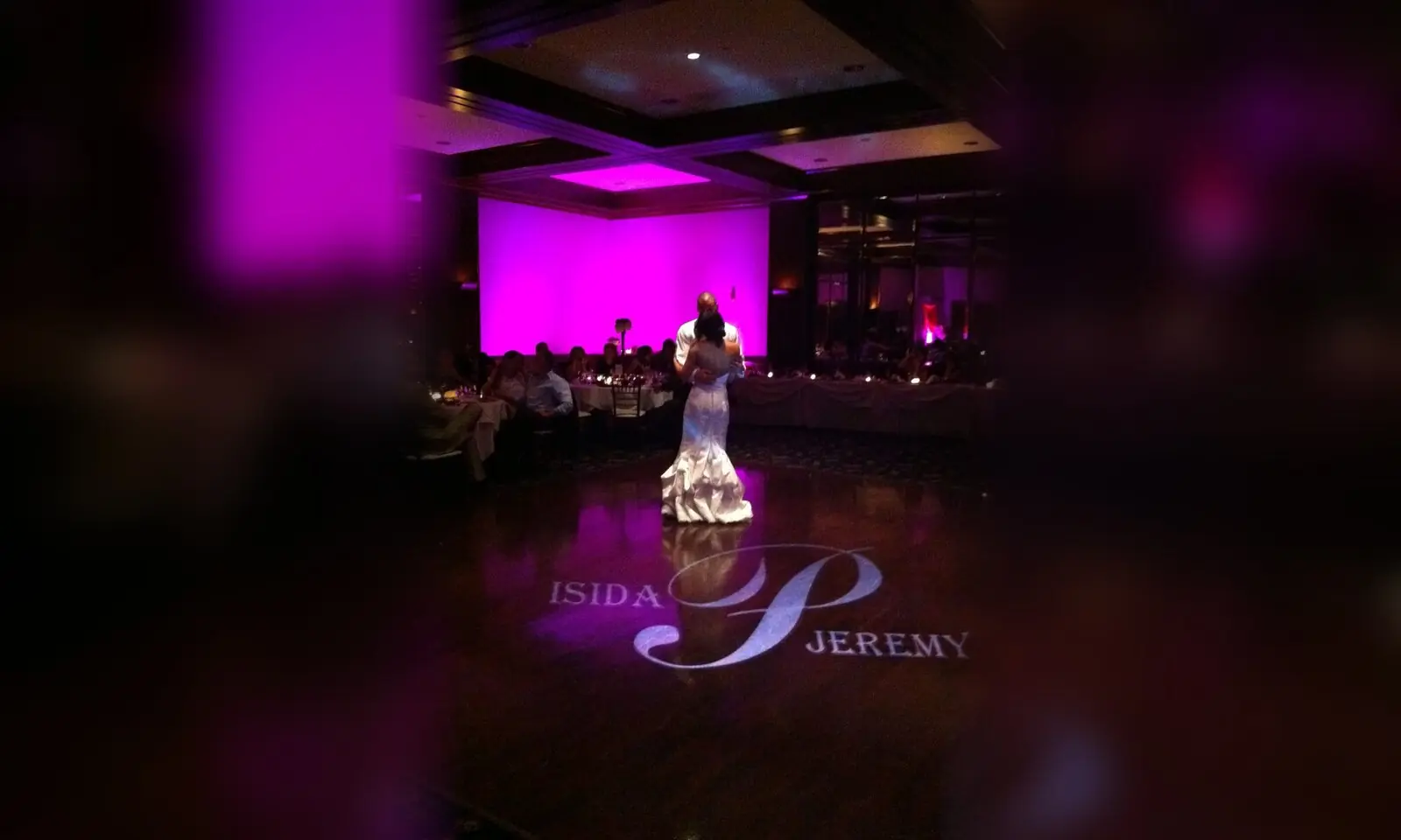 Fuchsia uplighting and a monogram on the dance floor during a first dance