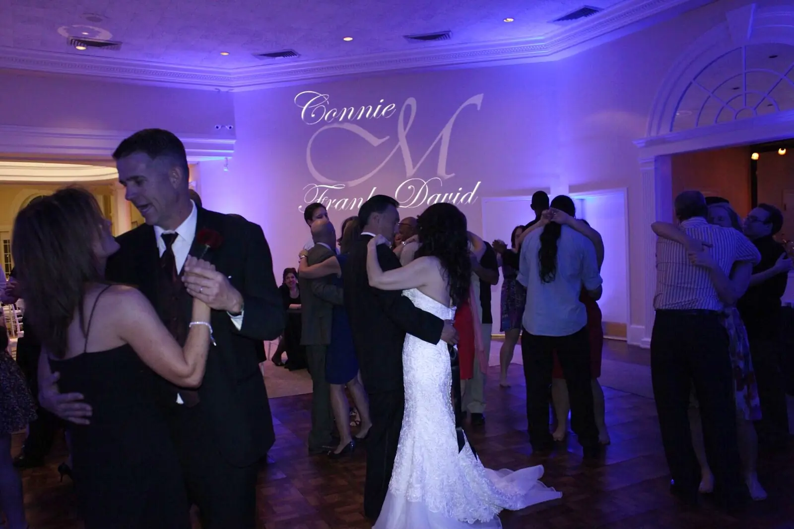 Violet uplighting and a custom monogram at a wedding reception